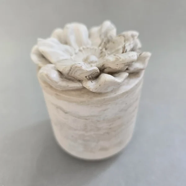 Vela aromática con recipiente en forma de flor fabricada en jesmonite con cera de soja natural. su mecha es de algodón bañada en soja.